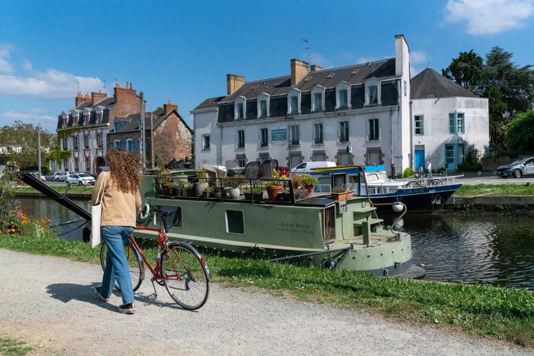 canal saint martin, une femme se promène avec son vélo