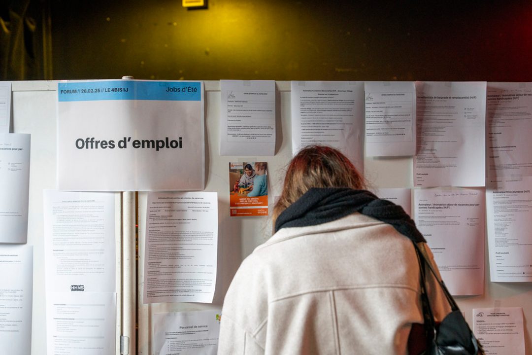 Femme consultant un tableau d'offres d’emploi.