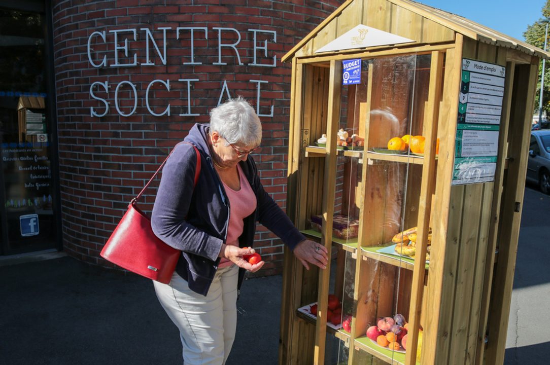 Femme se servant en légumes en libre-service devant le Centre social Cleunay.